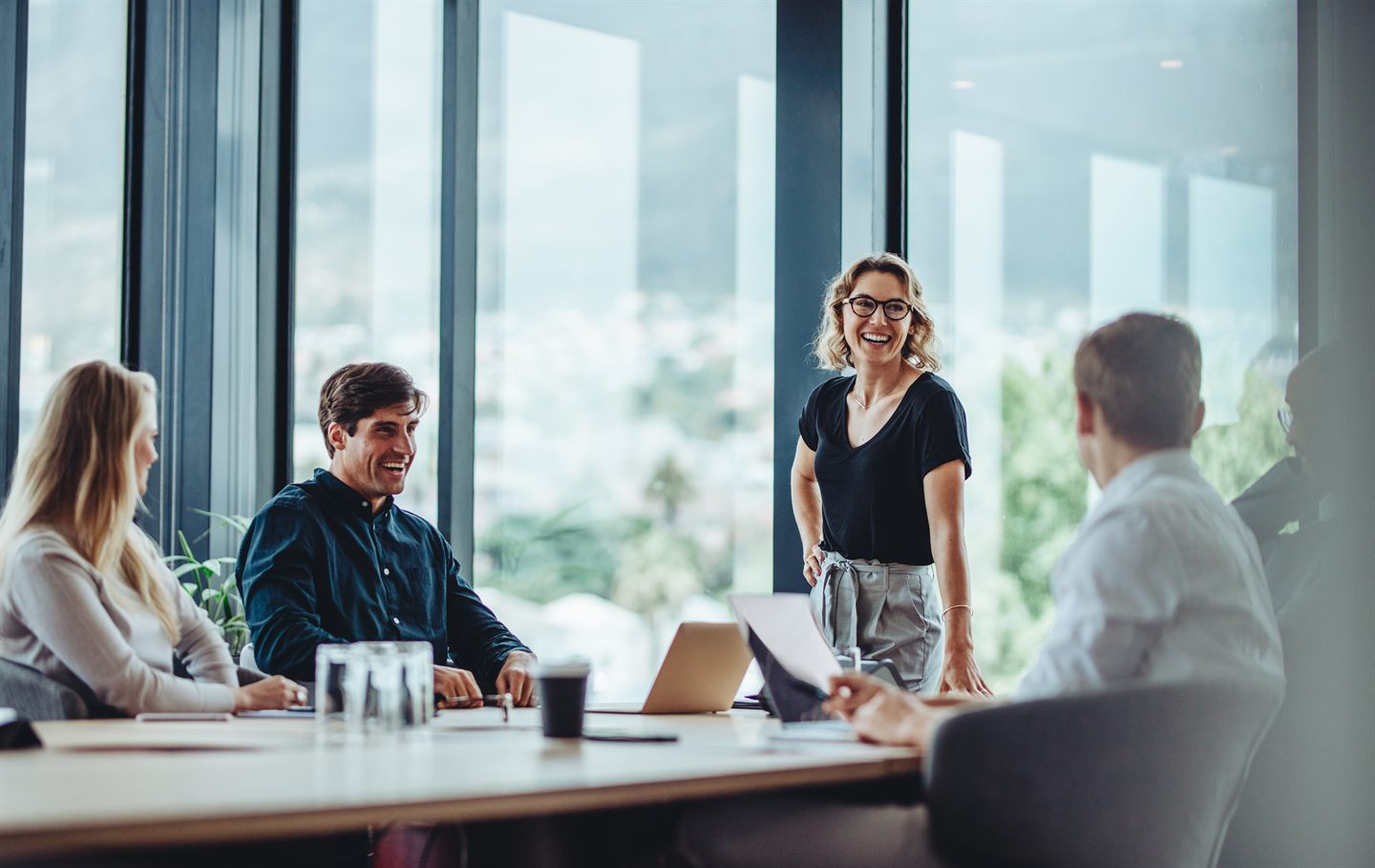 Colleagues collaborating in a glass-walled meeting room