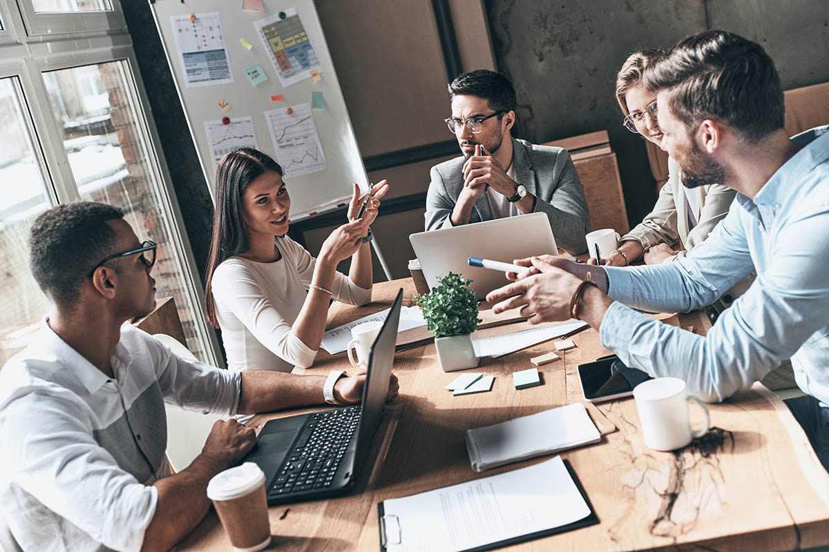 Team at work. Top view of young modern people in smart casual we Team at work. Top view of young modern people in smart casual wear discussing business while working in the creative office
