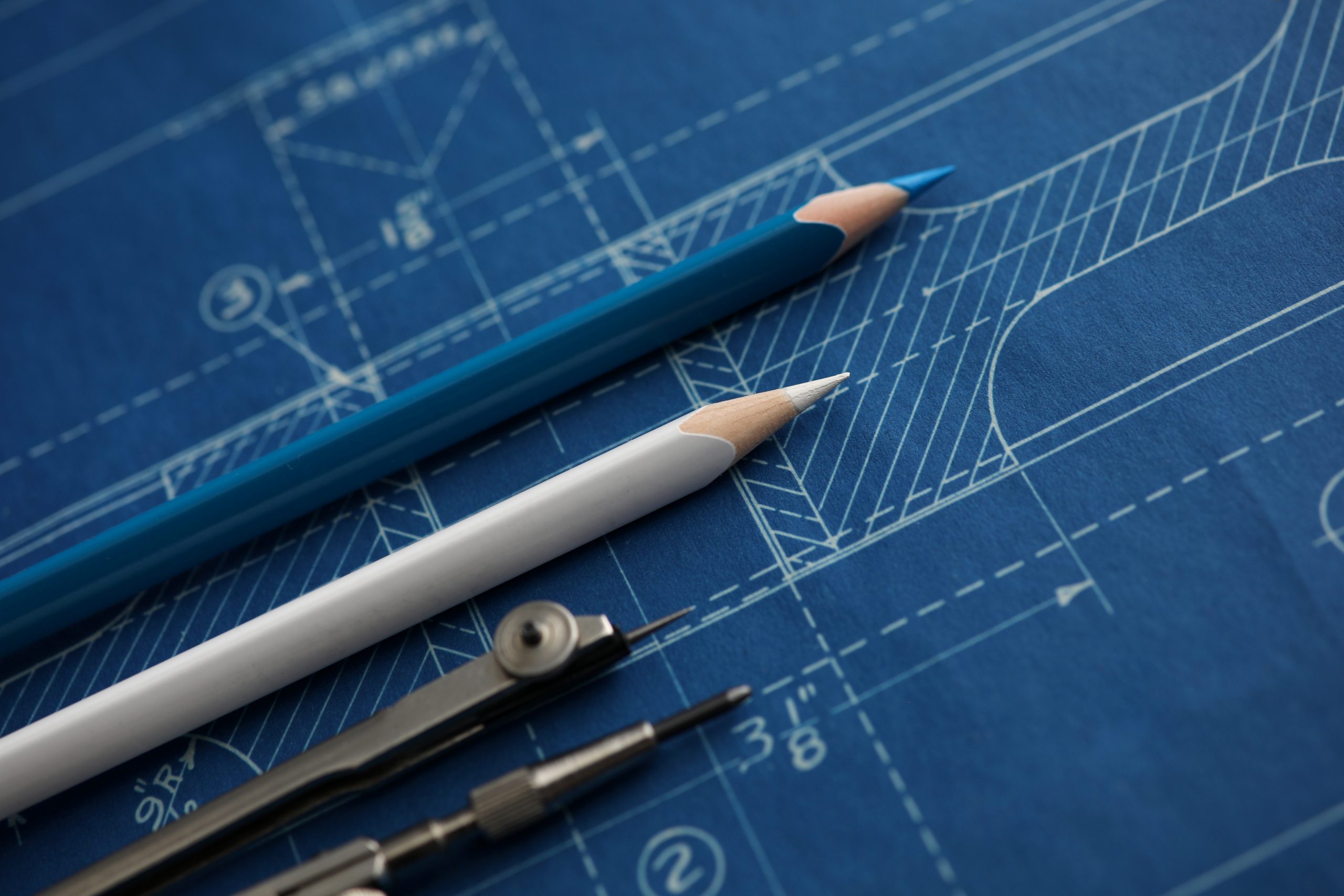 Drawing tools lying over blueprint paper Drawing tools lying over blueprint paper
